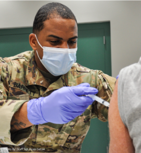 A member of the National Guard administering the COVID vaccine