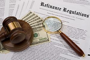 A magnifying glass sits on a document about refinance regulations